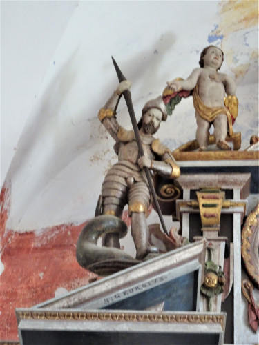 Sv. Juraj ubija zmaja, polikromirano i pozlaćeno drvo, atika bočnog oltara u pavlinskoj crkvi Rođenja BDM u Sveticama, 17. st.